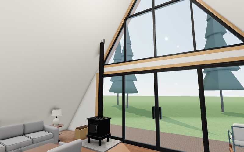 Echo House vaulted living room with a black wood stove beside the floor-to-ceiling glass gable, pines outside